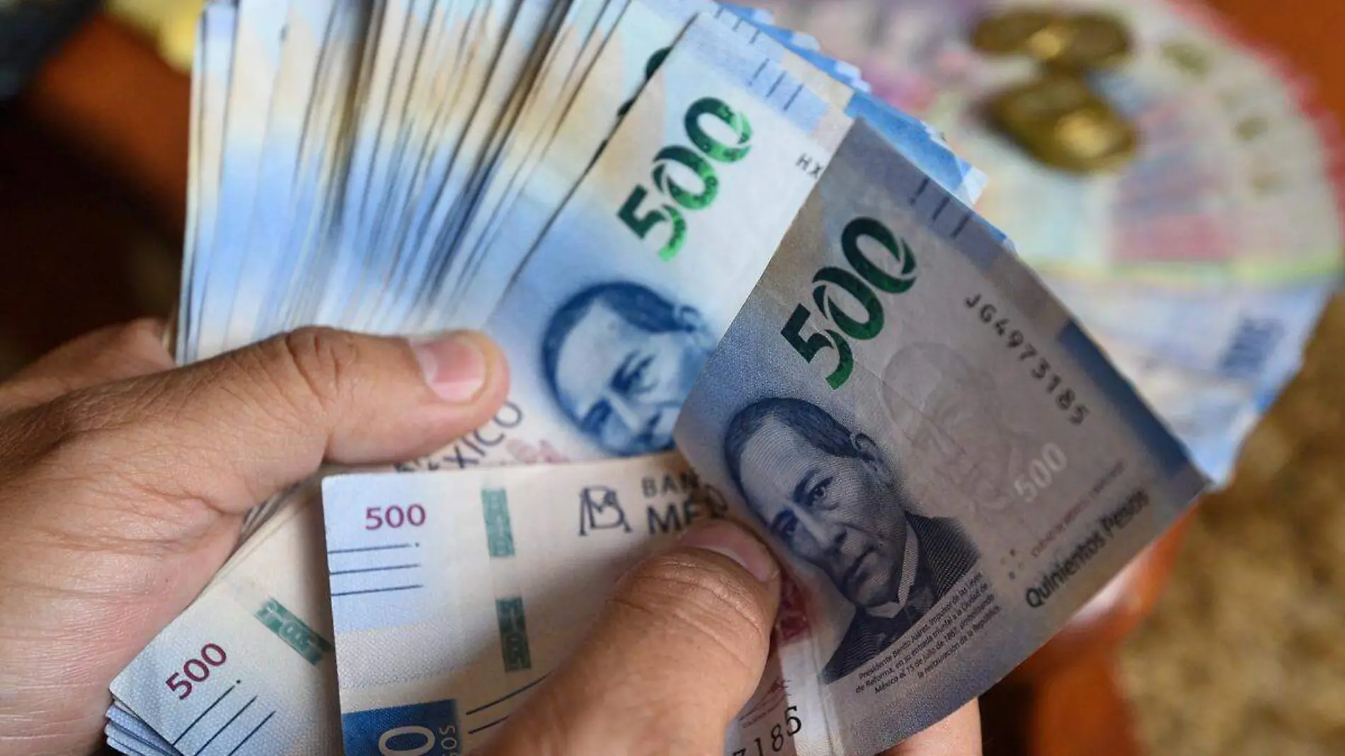 billetes de 500 pesos sostenidos por una mano